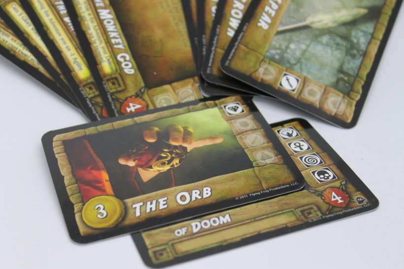 Carte artefatto e carte avventura del gioco in scatola Fortune and Glory: the Cliffhanger Game